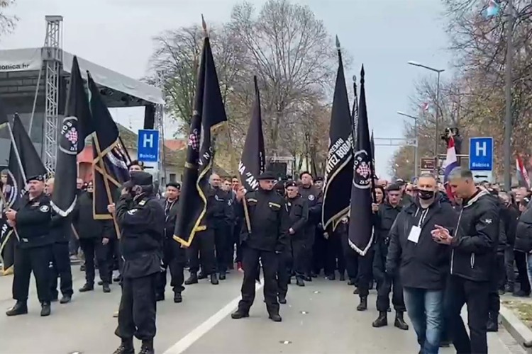 Pripadnici HOS u Vukovaru sa zastavama na kojima piše "za dom spremni"